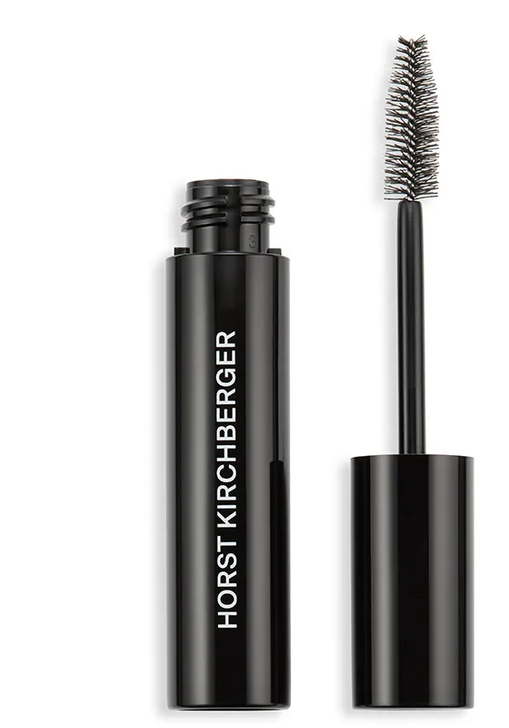 Eine geöffnete Mascara in einem glänzenden schwarzen Behälter. Der Bürstenapplikator befindet sich rechts vom Behälter, der mit dem Schriftzug "Horst Kirchberger" versehen ist.
